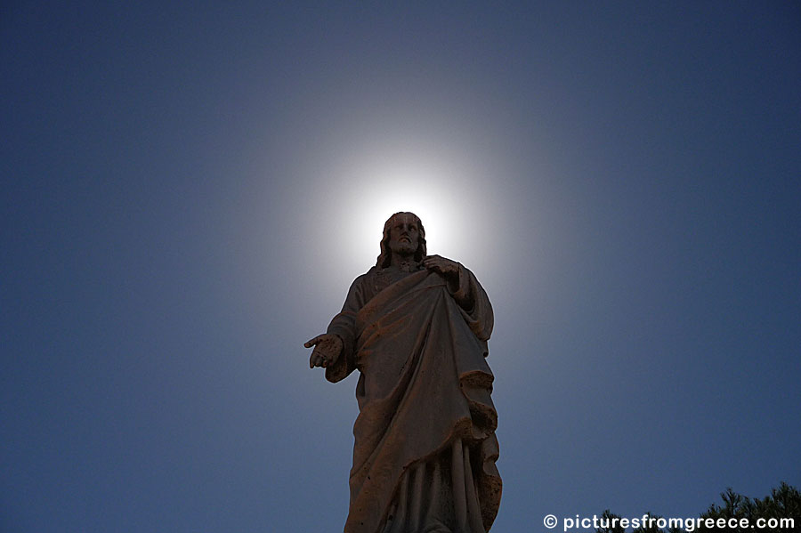 At the cemetery below the mountain and castle Exobourgos in Tinos is a beautiful statue of Jesus.